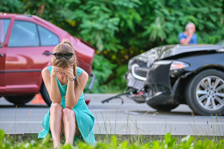 sad female driver sitting street side shocked after car accident road safety vehicle insurance concept 768x512