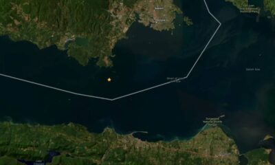 Satellite view of the ocean with a white polygonal route along the coast; a yellow star marks a point offshore.