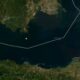 Satellite view of the ocean with a white polygonal route along the coast; a yellow star marks a point offshore.