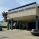 Gig Harbor High School entrance with blue columns and circular concrete planters on a sunny day