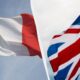 French flag and UK flag fluttering in the wind, separated by a white seam. (informative)