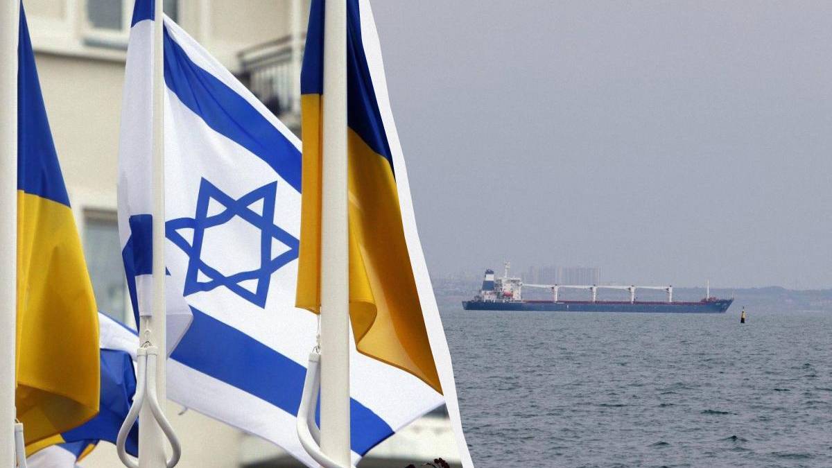 Israeli and Ukrainian flags in the foreground with a cargo ship on the sea in the background.