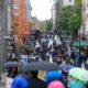Busy city shopping street on a rainy day crowded with pedestrians and umbrellas.