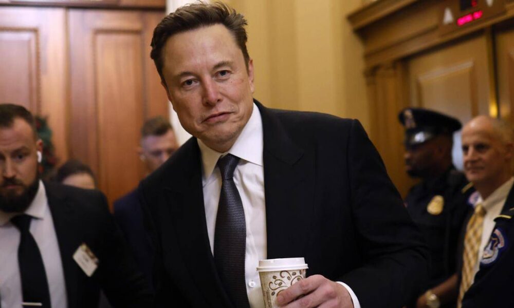 Man in a dark suit and tie holding a coffee cup in a formal hallway, with security personnel nearby on both sides of the scene.