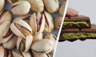 Pile of pistachio nuts on the left and pistachio-filled chocolate bars on the right, split by a diagonal divider.