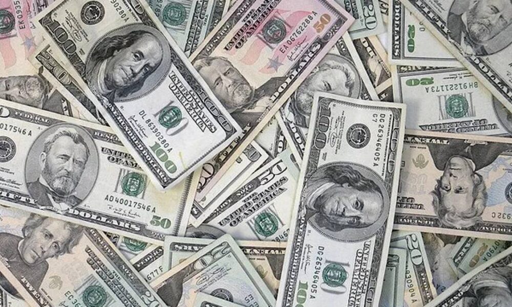 Assorted US dollar bills scattered and overlapping on a surface.