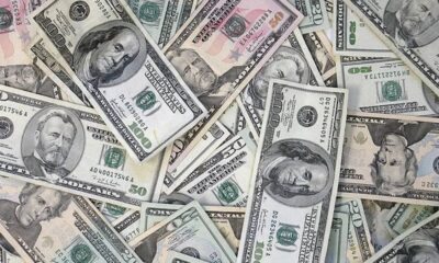 Assorted US dollar bills scattered and overlapping on a surface.