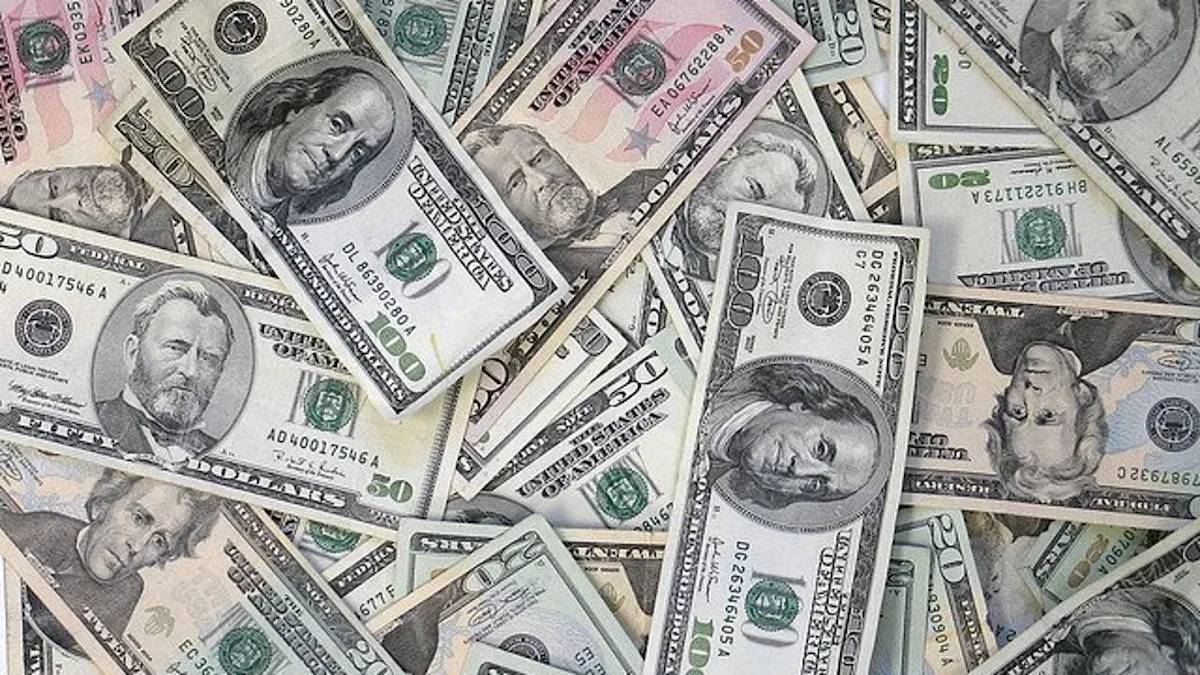 Assorted US dollar bills scattered and overlapping on a surface.