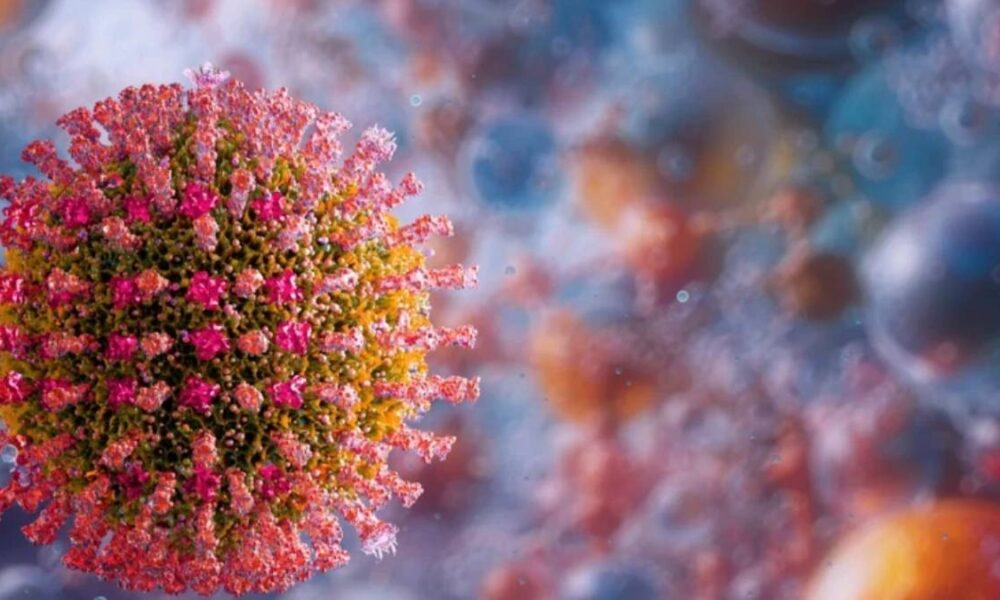 Close-up of a coronavirus particle with pink spike proteins against a blurred background, illustrating the virus structure.