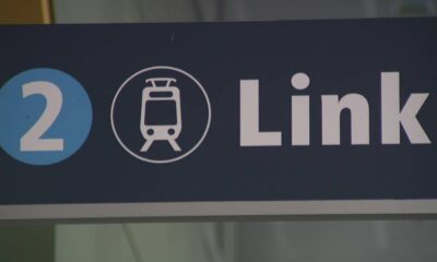 Sign showing the number 2 and a tram icon with the word 'Link' on a dark background, indicating a transit line