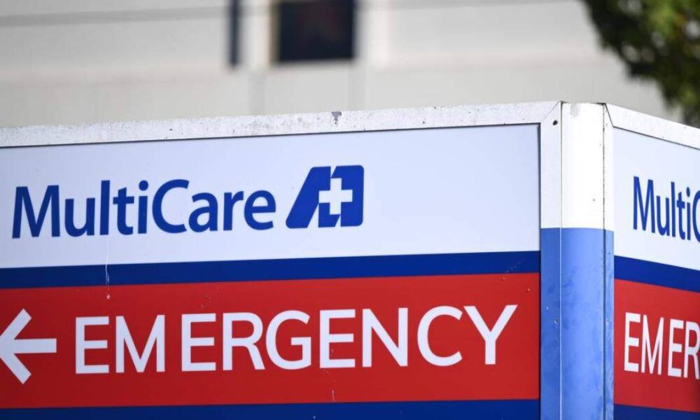 Emergency department sign featuring MultiCare branding, with a red banner reading 'EMERGENCY' and a white arrow nearby.