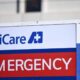 Emergency department sign featuring MultiCare branding, with a red banner reading 'EMERGENCY' and a white arrow nearby.