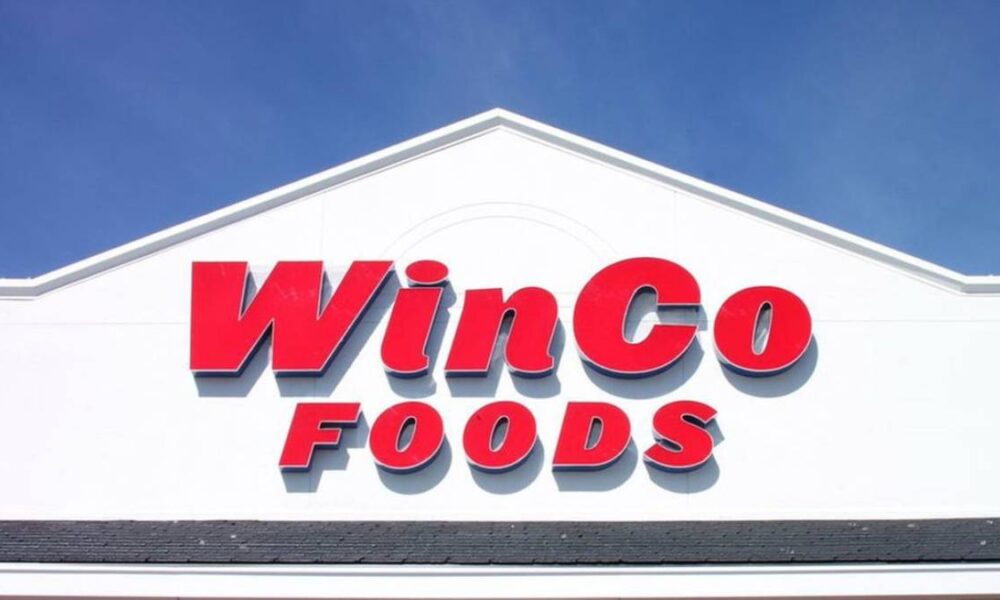 WinCo Foods store sign on a white building against a blue sky