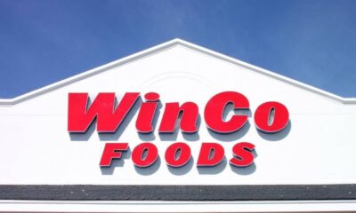 WinCo Foods store sign on a white building against a blue sky