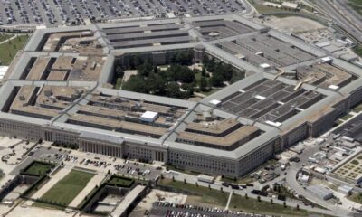 Aerial view of the U.S. Pentagon building with its distinctive five-sided shape and central courtyard, seen from above.