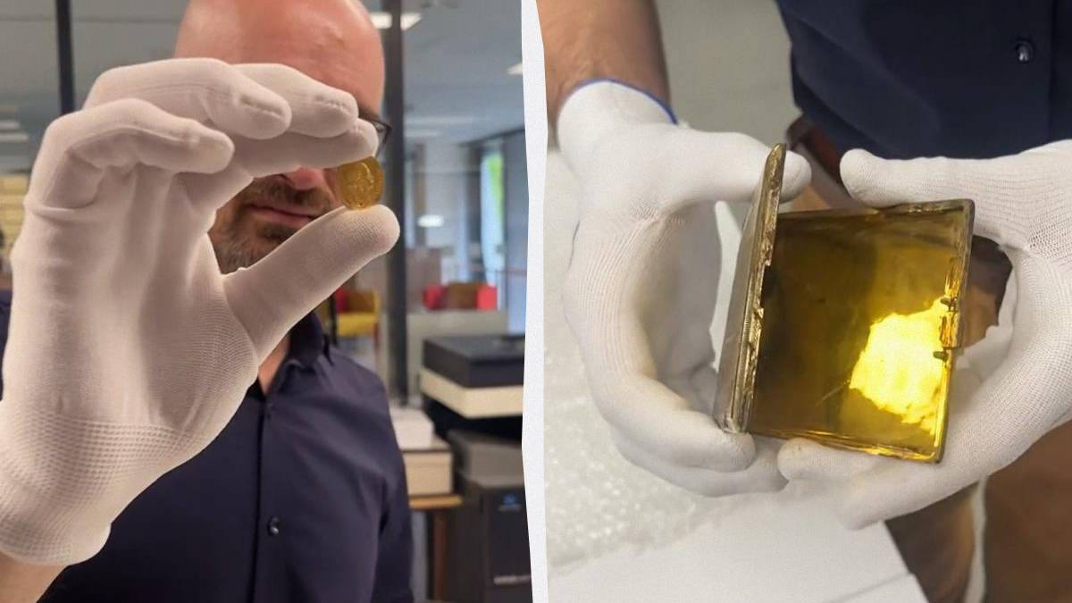 Man in gloves holding a small gold coin up to the camera in a shop or lab setting.