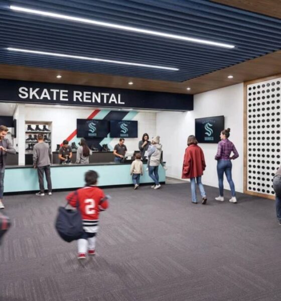 Skate rental counter in a modern lobby with customers queuing and a child walking away.