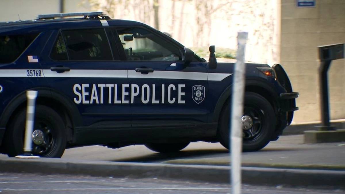 Seattle Police Department SUV with 'SEATTLEPOLICE' lettering parked on a city street, badge visible on the side.