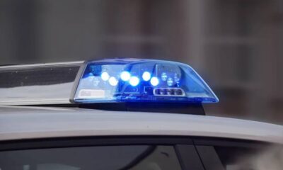 Police car roof with flashing blue emergency lights on.