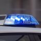 Police car roof with flashing blue emergency lights on.