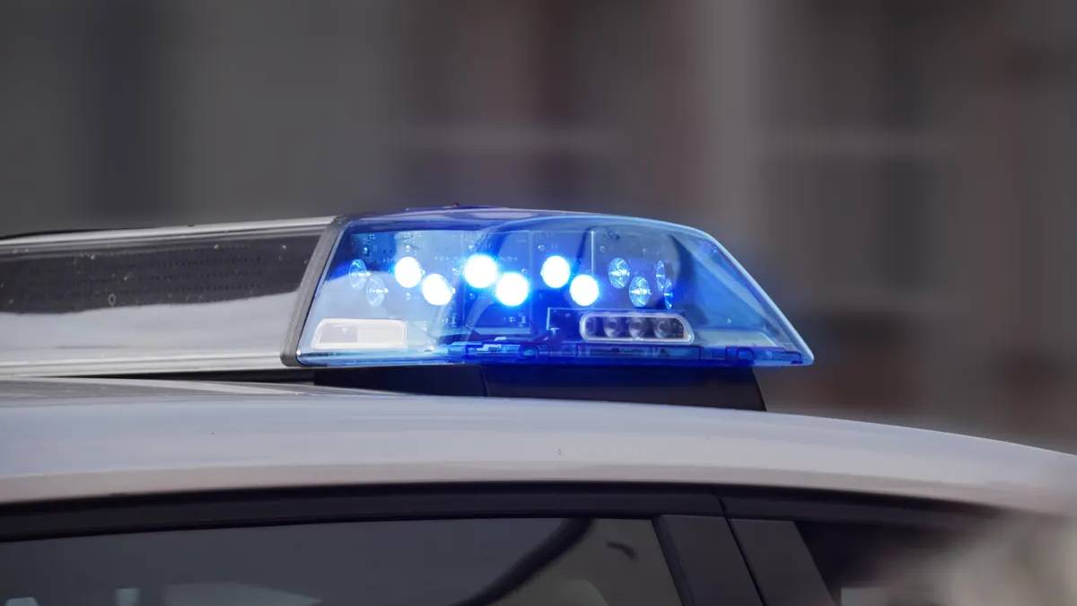Police car roof with flashing blue emergency lights on.