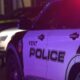 Kent Police SUV at night with red and blue emergency lights flashing; police tape in the background.