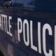 Side view of a dark blue Seattle Police vehicle with large white 'SEATTLE POLICE' lettering on the door.