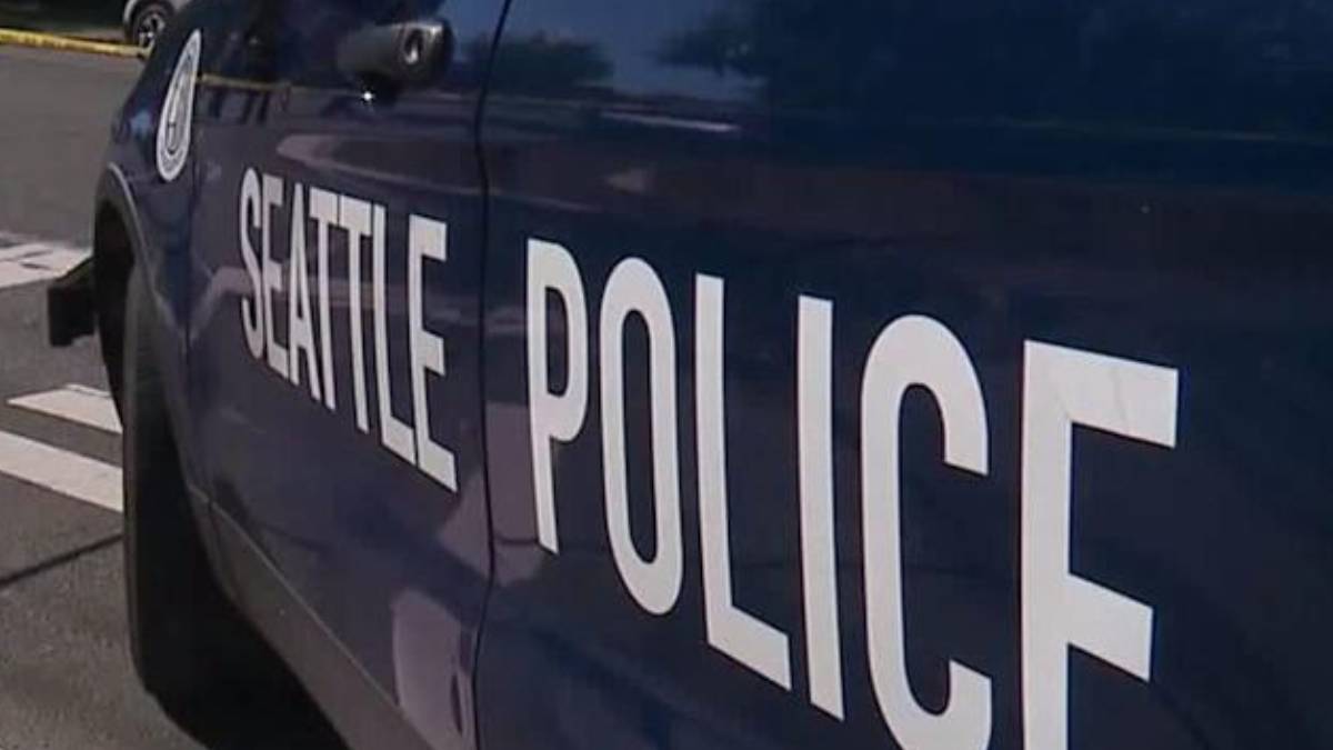 Side view of a dark blue Seattle Police vehicle with large white 'SEATTLE POLICE' lettering on the door.