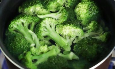 Steamed broccoli florets boiling in a pot of water, bright green and ready to eat, with stems visible