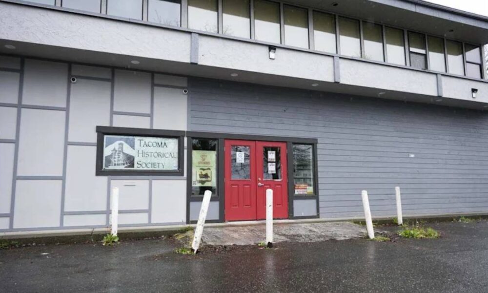 Front of the Tacoma Historical Society building with red double doors and a sign reading 'Tacoma Historical Society' beside the entrance.