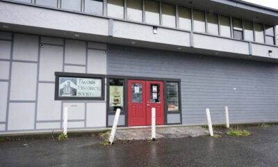 Front of the Tacoma Historical Society building with red double doors and a sign reading 'Tacoma Historical Society' beside the entrance.