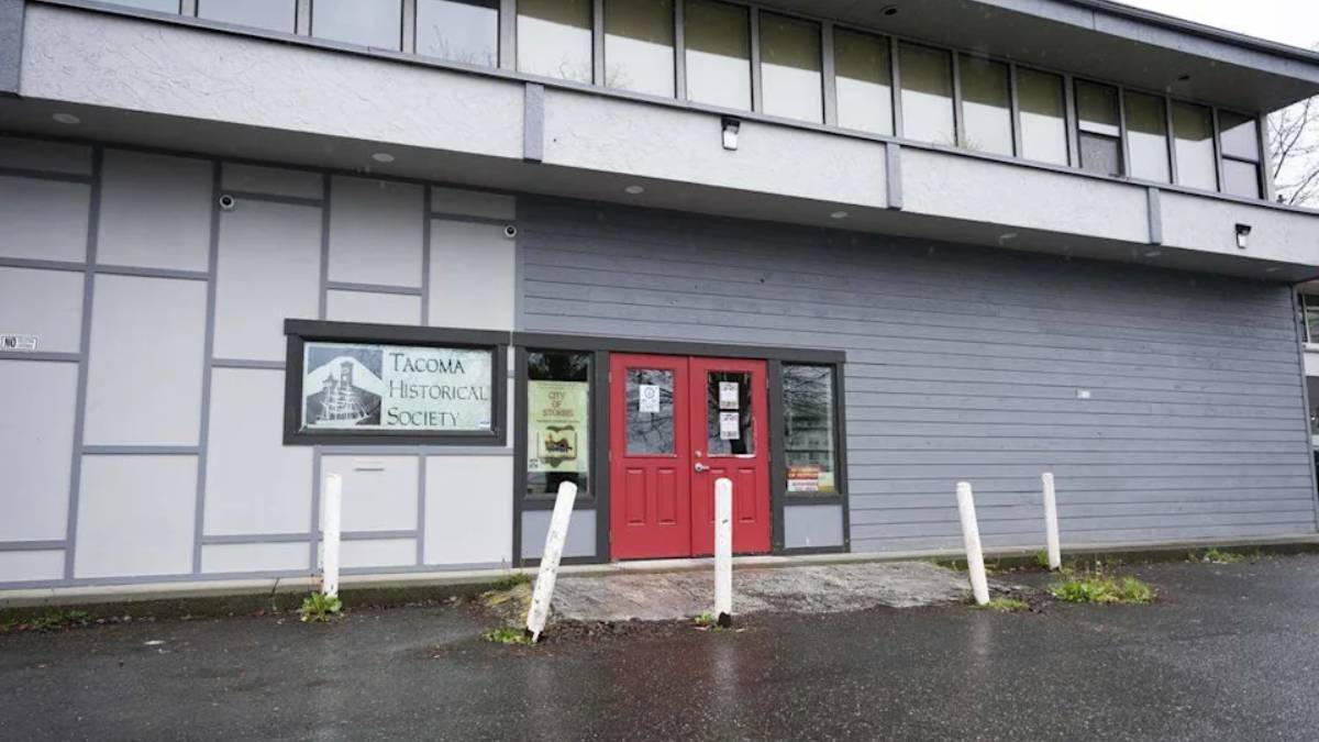 Front of the Tacoma Historical Society building with red double doors and a sign reading 'Tacoma Historical Society' beside the entrance.