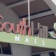 Sign reading SouthHill Mall with a green panel and leaf logo at an outdoor entrance. May be used for mall or shopping center context.