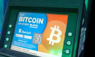 Bitcoin ATM screen advertising Bitcoin purchase with a large Bitcoin logo and colorful display.