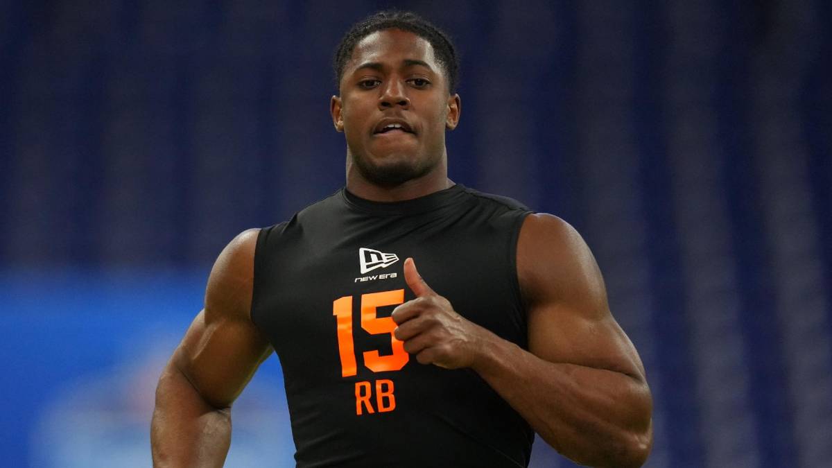 Athlete wearing a black sleeveless jersey with orange number 15 and RB, running on a field indoors.
