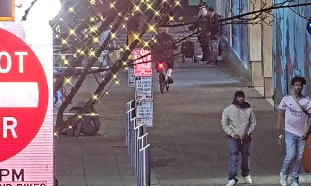 Sidewalk scene with decorative string lights, a large DO NOT ENTER sign on the left, and several people near a muraled wall.