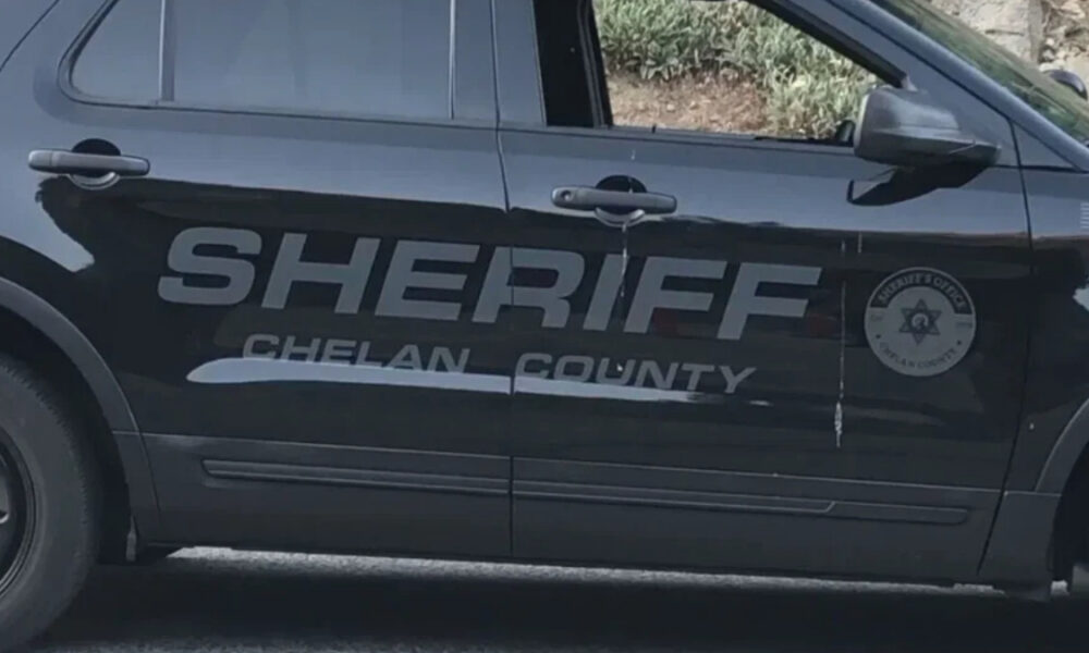 Black Sheriff SUV side with 'SHERIFF' lettering and 'CHELAN COUNTY' logo on the door surface