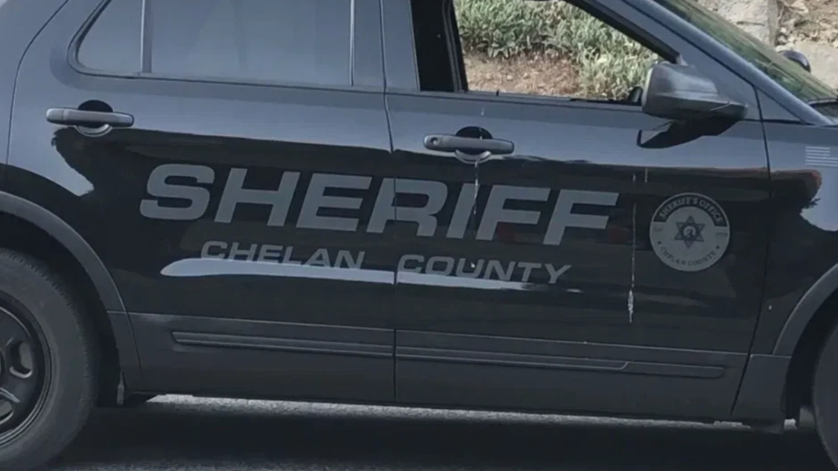 Black Sheriff SUV side with 'SHERIFF' lettering and 'CHELAN COUNTY' logo on the door surface