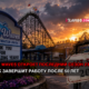 Sunset at Wind Waves Theme & Water Park with a wooden roller coaster in the background and a 'Thank you for 50 amazing years' sign, plus a weathered 'Season' sign on a chain-link fence in the foreground.