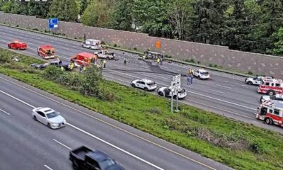 Multiple vehicles involved in a highway crash with emergency responders on a divided freeway median.