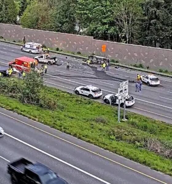 Multiple vehicles involved in a highway crash with emergency responders on a divided freeway median.