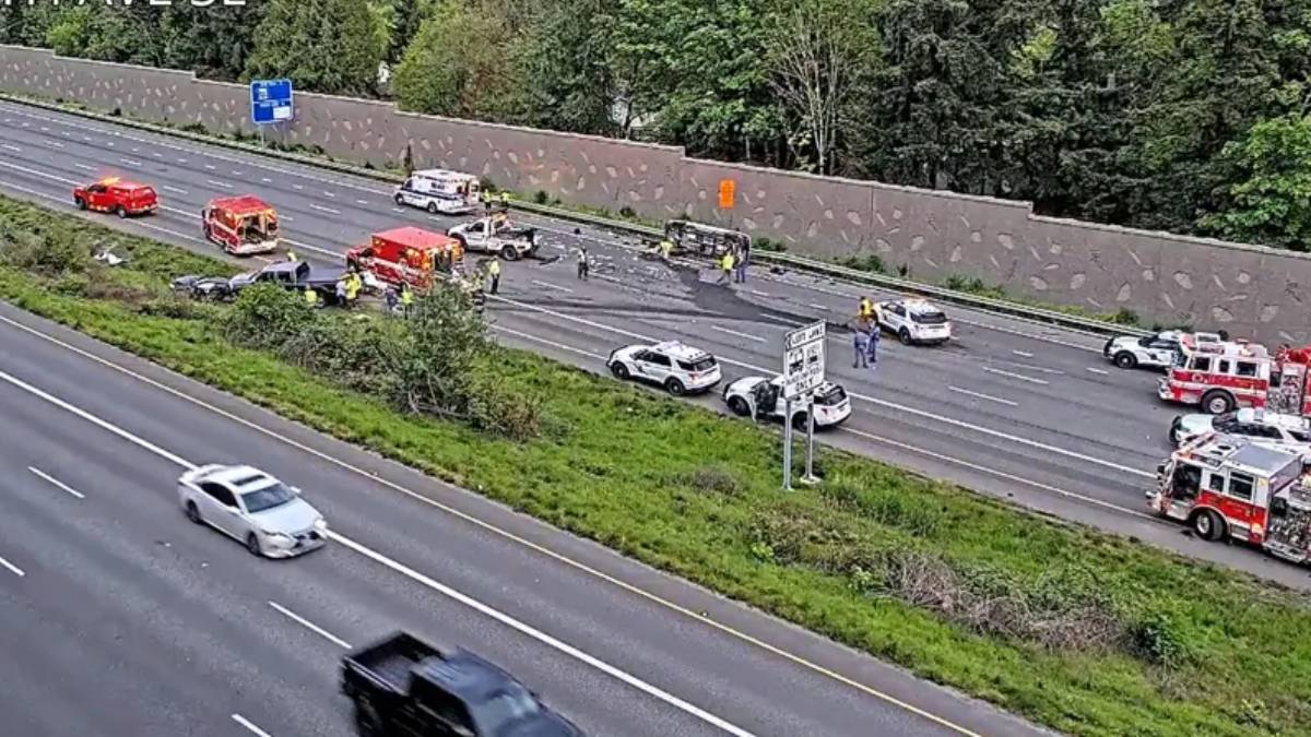Multiple vehicles involved in a highway crash with emergency responders on a divided freeway median.
