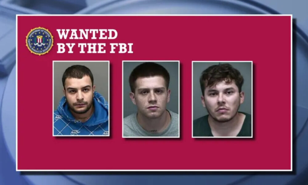FBI wanted poster on a maroon background showing three mugshots beneath 'WANTED BY THE FBI' with the FBI seal in the corner for context.
