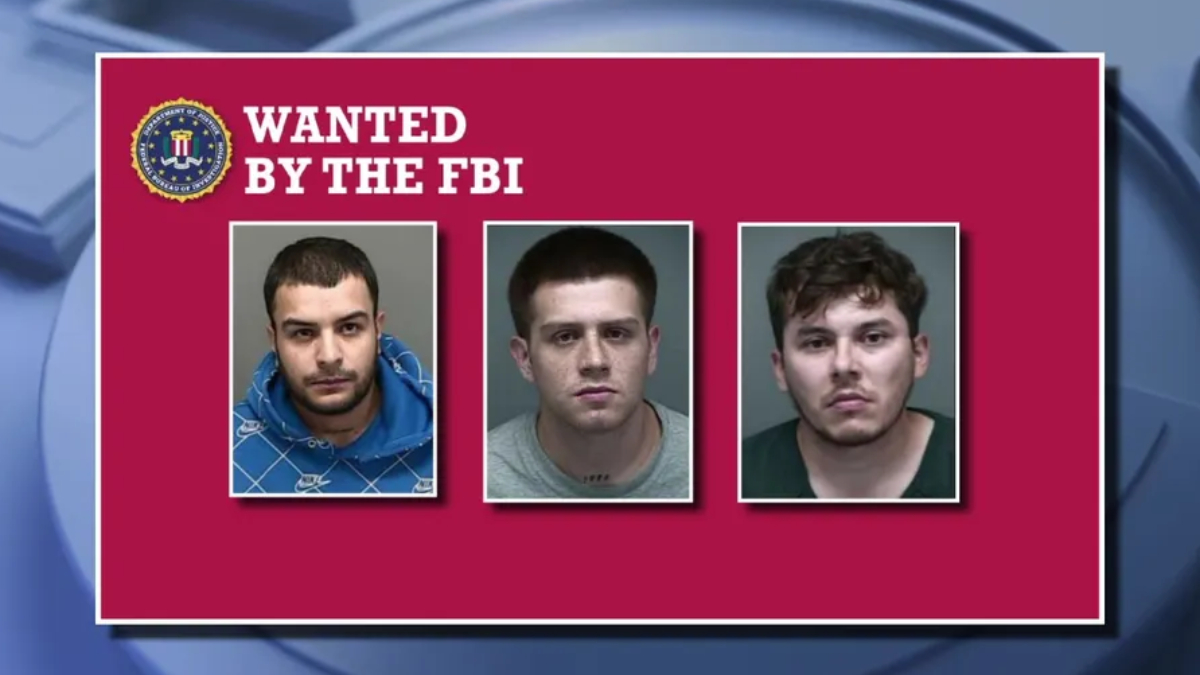 FBI wanted poster on a maroon background showing three mugshots beneath 'WANTED BY THE FBI' with the FBI seal in the corner for context.