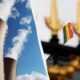 Split image: industrial cooling towers on the left with a blue sky, and a Belgian flag near a gold-ornate fence on the right
