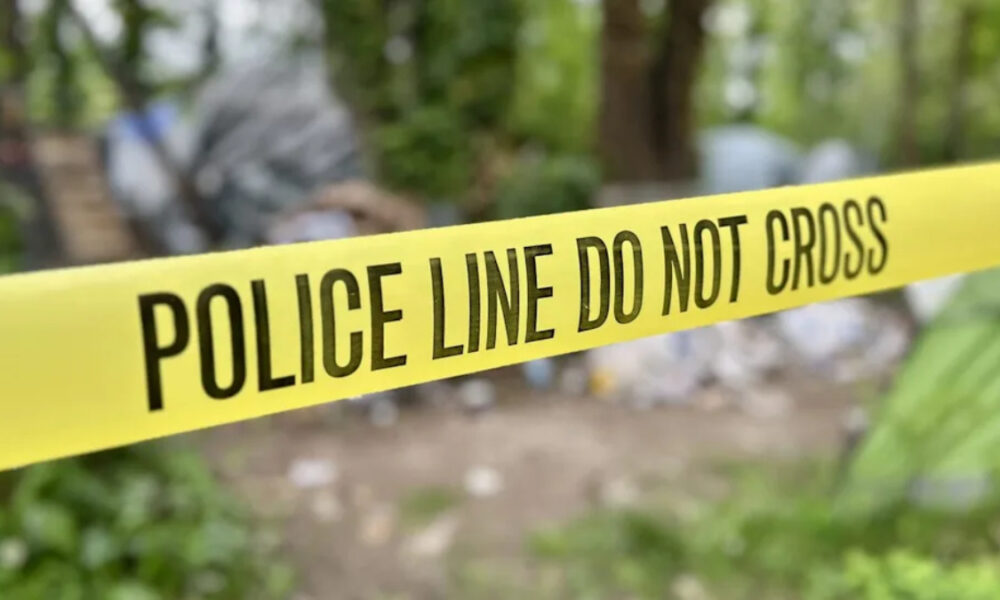 Yellow police tape stretched across an outdoor scene with the words 'POLICE LINE DO NOT CROSS' visible, indicating a restricted area
