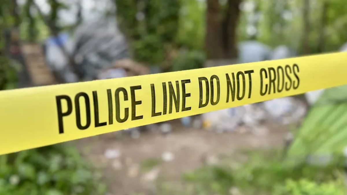 Yellow police tape stretched across an outdoor scene with the words 'POLICE LINE DO NOT CROSS' visible, indicating a restricted area