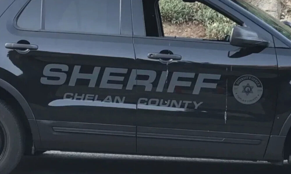 Black sheriff SUV side with large 'SHERIFF CHELAN COUNTY' lettering and a circular sheriff badge on the front door