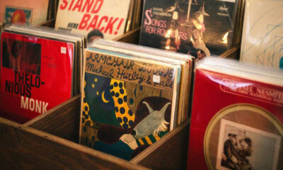 Close-up of wooden bins filled with colorful vinyl records in a record shop, with a bright red Thelonious Monk album visible on the left.
