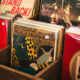 Close-up of wooden bins filled with colorful vinyl records in a record shop, with a bright red Thelonious Monk album visible on the left.